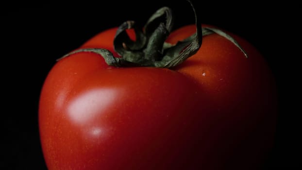 Close up of red juicy tomato on black background. Frame. Food concept.