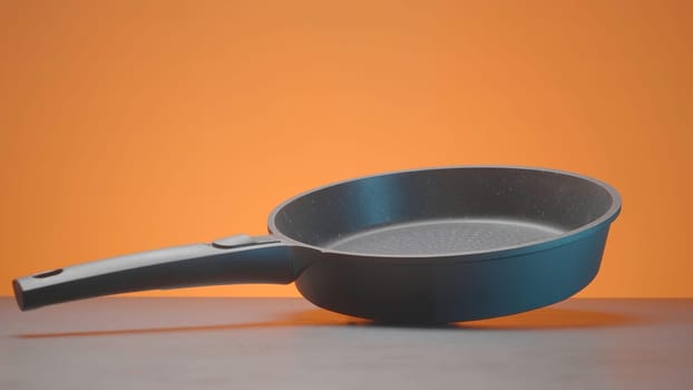 New pan with non-stick coating. Action. Modern stylish coated frying pans. New frying pans for cooking. Kitchen utensils.