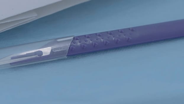 Close-up of medical scalpel. Action. One of models of scalpels for doctors. Scalpel with comfortable handle. Surgical introduction.