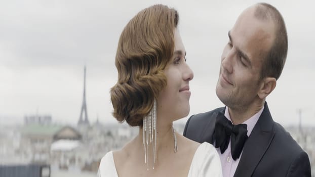 A beautiful couple against the background of nature and wind. Action. A beautiful brunette woman with curled hair and her love in a suit tenderly look at each other. High quality 4k footage