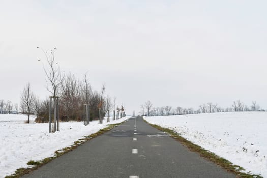 Road raked by snow plough in winter. Roads cleared by plough in winter. Concept of winter and winter road care.