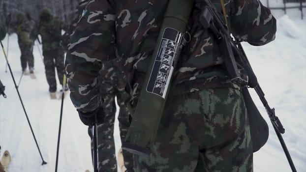 Soldier with weapons in cold forest. Winter warfare and military concept. Clip. Soldiers in winter forest on skis with guns. Military exercises in the forest in slow motion.