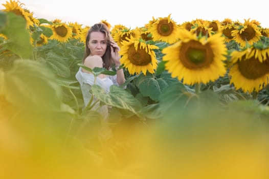 Portrait of beautiful woman posing in field with sunflowers, enjoying nature and summer.