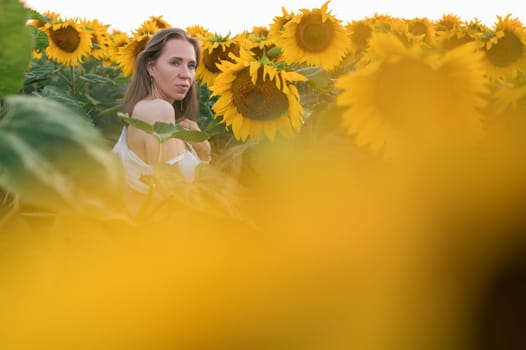 Portrait of beautiful woman posing in field with sunflowers, enjoying nature and summer.