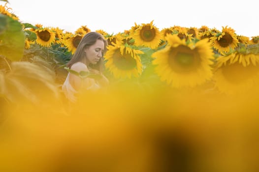 Portrait of beautiful woman posing in field with sunflowers, enjoying nature and summer.