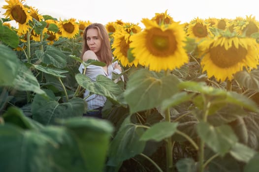 Portrait of beautiful woman posing in field with sunflowers, enjoying nature and summer.