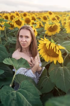 Portrait of beautiful woman posing in field with sunflowers, enjoying nature and summer.