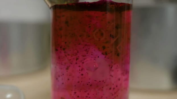 Colored beautiful chemical reaction in flask. Pink or red liquid dissolves in flask. Pink matter in the flask. Pink or red liquid dissolves in flask 4K