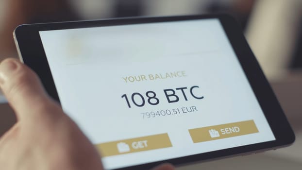 Man checks the account on the tablet. Stock. Checking the bitcoin balance on the account.