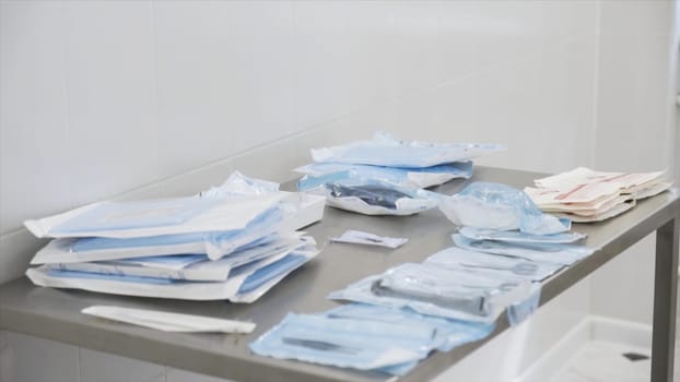 Medical laboratory details, a set of sterile disposable instruments lying on the table. Close up of medical tools, surgical equipment, concept of medicine.