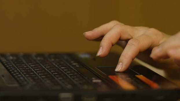 A Woman's hand with the fingers on a laptop mousepad. Woman's hand using laptop mouse 4K