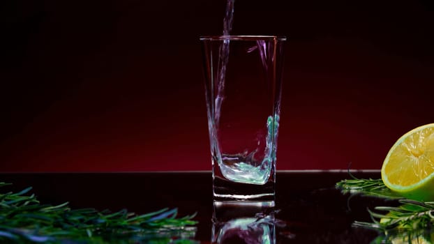 Close up of filling an empty glass with fresh green drink. Stock clip. Details of a bar counter with a half of an orange fruit and rosemary