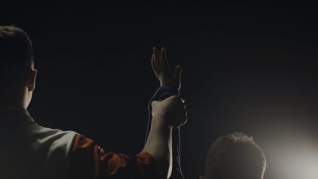 Rear view of the referee who raises the winner's hand. The referee raises the hand of the boy winner in the ring.