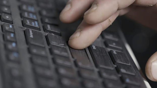 Close-up of finger over black laptop keys pressing enter button, computers and technologies concept. Man finger pushing enter key on black laptop keyboard.