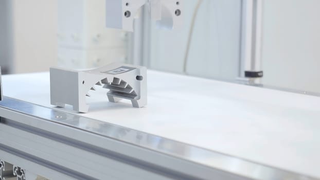 Robotic arm lifts detail. Media. The robotic arm use in detail parts production line. The hi-technology mechanical parts manufacturing process in industrial concept.