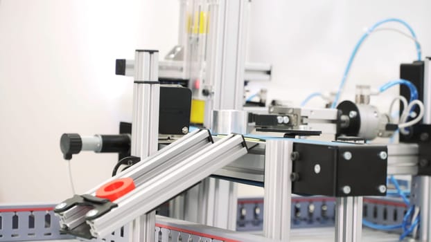 The robotic arms holding hollow tubes and putting them on the conveyor line. Automated machine placing sleeve details on the production lines.