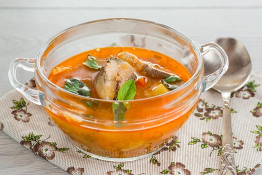 vegetable tomato soup with fish in a plate on a wooden table