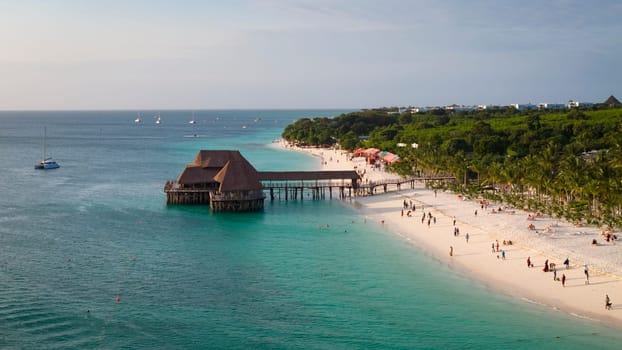 Landscape of coastline at sunny day, drone view of sandy beach, turquoise ocean,palm tree, luxury resort and people, Zanzibar,Tanzania