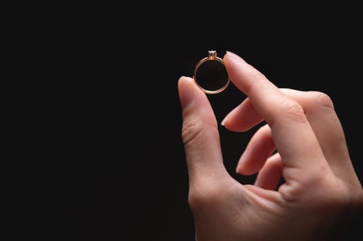the ring is held with the fingers, demonstrating the diameter of the ring and its type. jewelry in a woman's hand.