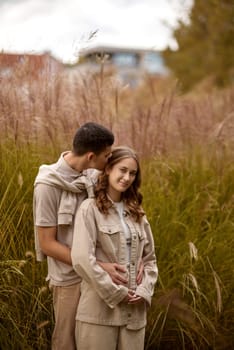 Young Cute Female Hugs Boyfriend. In Autumn Outdoor. Lovers Walking in Park. Attractive Funny Couple. Lovestory in Forest. Man and Woman. Cute Lovers in the Park. Family Concept. Happy Couple.