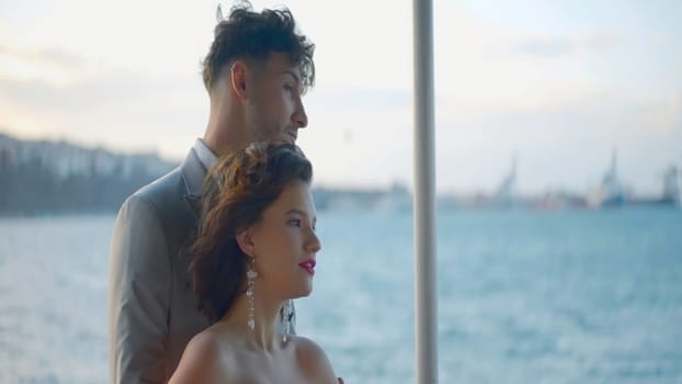 Couple in love relaxing on the yacht and enjoying picturesque view and each other. Action. Man and woman hugging each other during their trip on yacht