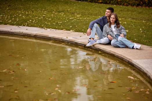 lovely young couple kissing outdoors in autumn. Loving couple walking in nature. Autumn mood. Happy man and woman hugging and kissing in autumn. Love. Fashionable couple outdoors. Fashion, people and lifestyle. Stylish couple in autumn outfit.