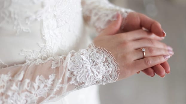 Close up of elegant ring on the finger. Soft and selective focus. Close-up of tender ring on bride's hand with white nails.