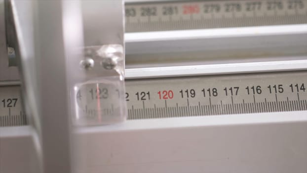 Close-up of worker of furniture factory measuring a wooden block with industrial measuring device. Production, manufacture and woodworking industry concept