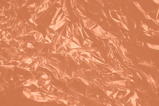 Texture foil Peach Fuzz color. Background for your design. Crumpled colored Peach Fuzz foil. High quality photo