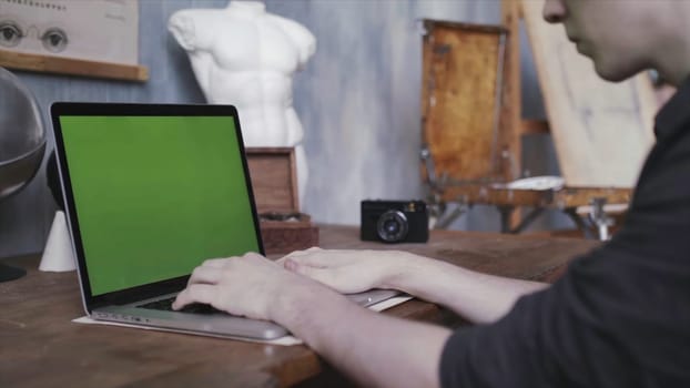 Close-up of man's hands typing on laptop with green chroma key screen. Laptop new technology concept, chroma key green screen