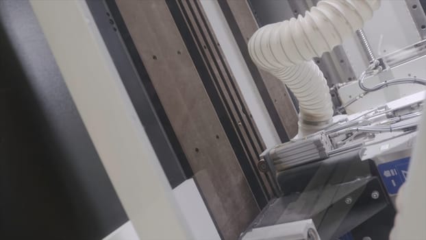 Modern machine making cuts on wooden boards. Action. Professional equipment at woodworking enterprise. Large multitasking machine working with wooden products.