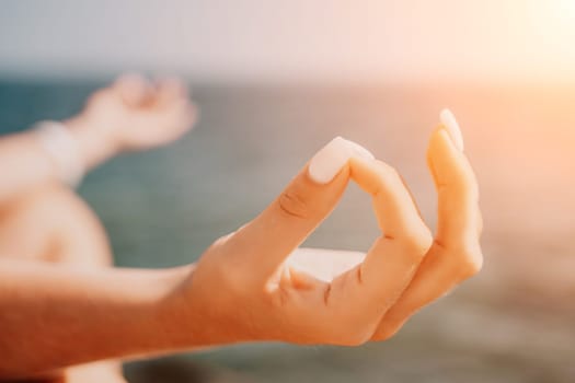 Woman sea yoga. Back view of free calm happy satisfied woman with long hair standing on top rock with yoga position against of sky by the sea. Healthy lifestyle outdoors in nature, fitness concept.