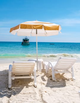 Koh Samet Island Rayong Thailand, beach chairs sunbed with umbrellas at the white tropical beach of Samed Island with a turqouse colored ocean on a sunny day