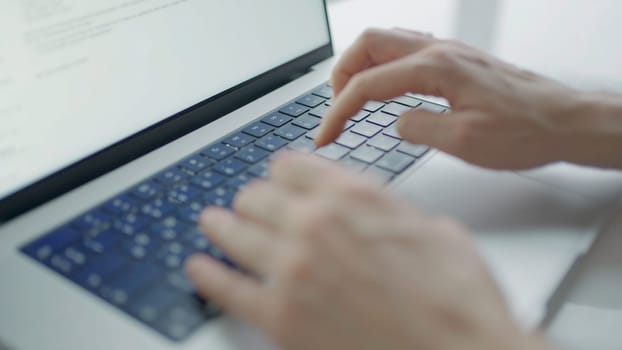 Close-up of hands typing text on laptop. Action. Beautiful hands print text on laptop. Writer or freelancer is typing on laptop.