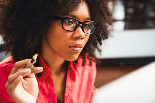 Portrait of young African woman creating website developer, thinking data information designer at home office, focusing on laptop. Concept of analytical data center in java project job. Tastemaker.