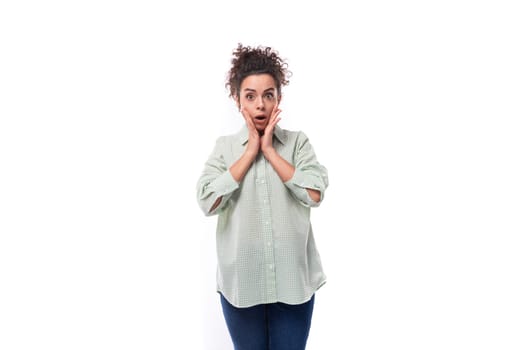 surprised young woman with curly messy hairstyle dressed in a shirt.