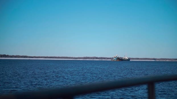 A snowy sea with ships.Clip. Huge ships with cargo move through the snowy sea, behind which the forest is visible. High quality FullHD footage