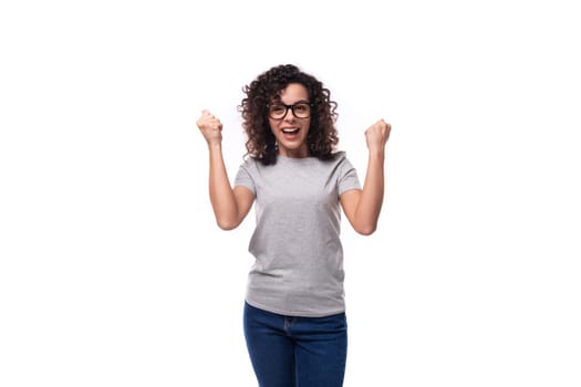 young cheerful pretty curly woman dressed in gray t-shirt with printable mockup.