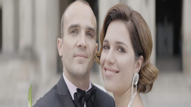 Wedding photography in tourist places. Action. A beautiful couple in smart suits walking around the square and posing for the camera. High quality 4k footage