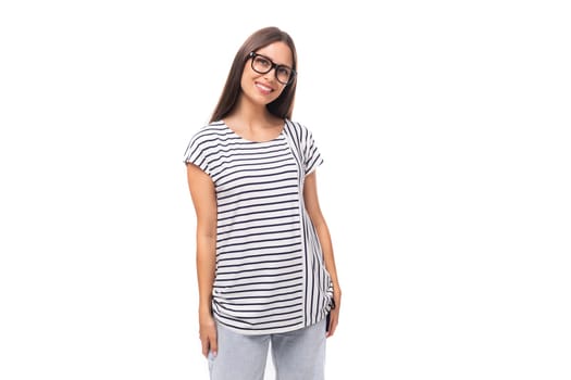 young european brunette woman in a striped sweater wears glasses for vision correction on a white background with copy space.