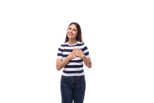 a young kind brunette caucasian woman with a light make-up dressed in a striped t-shirt and jeans wins over with a smile.