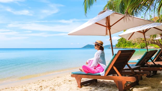 Asian Thai woman on a beach chair on the beach of Koh Samet Island Rayong Thailand, the white tropical beach of Samed Island with a turqouse colored ocean