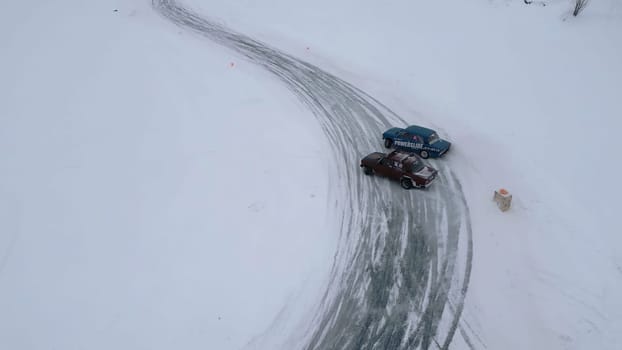 Winter fun filmed from a helicopter. Clip. Winter drift in cars that go to competitions and people watching around. High quality 4k footage