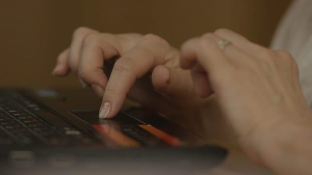 A Woman's hand with the fingers on a laptop mousepad. Woman's hand using laptop mouse 4K