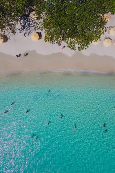 people swimming in the ocean during vacation at Koh Samet Island Thailand, aerial drone view from above at the Samed Island in Thailand with a turqouse colored ocean
