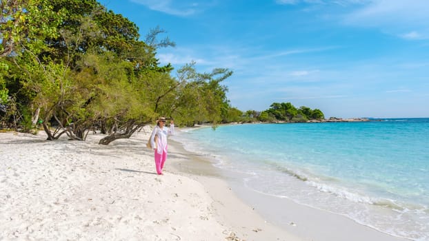 Asian woman walking on the beach of Koh Samet Island Rayong Thailand, the white tropical beach of Samed Island with a turqouse colored ocean