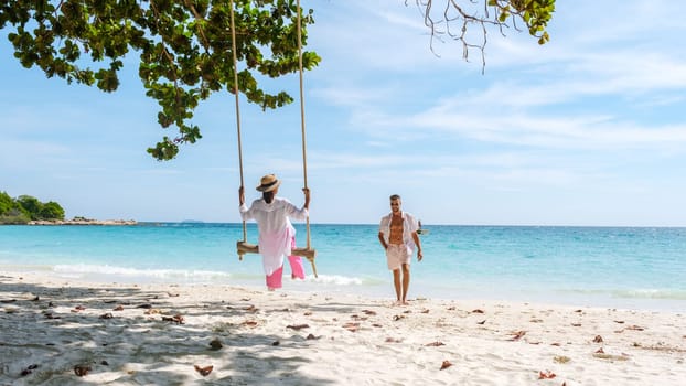 A couple of men and women at a swing on the beach of Koh Samet Island Rayong Thailand, a couple on honeymoon in Thailand