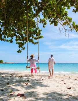 A couple of men and women at a swing on the beach of Koh Samet Island Rayong Thailand, a couple on honeymoon in Thailand