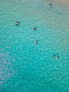 people swimming in a blue turqouse colored ocean at Koh Samet Island Thailand, aerial drone view from above at the Samed Island in Thailand