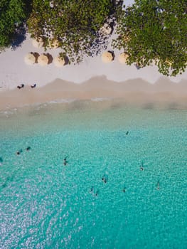 people swimming in a blue turqouse colored ocean at Koh Samet Island Thailand, aerial drone view from above at the Samed Island in Thailand